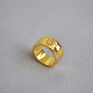 Macro detail of gold-plated North Star ring featuring hammered texture and zircon stone