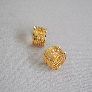 Detail view of handcrafted gold layered wire rings with white pearls and sparkling rhinestones