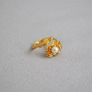 Detailed macro shot of vintage rose flower ring with gold leaves and pearl inlay