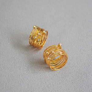Macro shot of gold-plated multi-layer spiral rings with rhinestones and white pearls