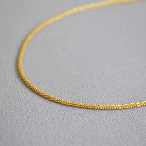 Macro shot of gold-plated brass choker showing sparkling popcorn chain texture details