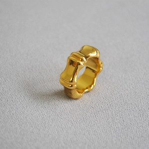 Macro detail of high-polish gold plated bamboo joint ring showing metallic mirror finish