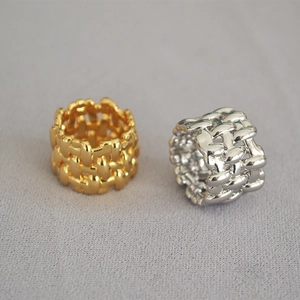 Detail of wide woven texture rings in polished gold and silver plating on fabric