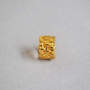 Macro shot of irregular woven mesh texture on wide gold-plated brass ring