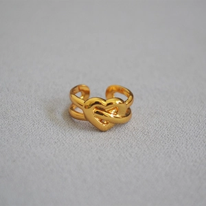 Detailed close-up of golden brass knotted heart open ring with intricate woven design