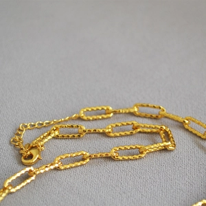 Collana a catena paperclip dorata con trama martellata e ciondolo moneta romana da donna