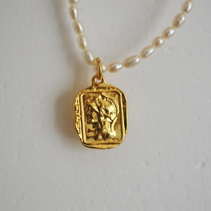 Elegant pearl necklace with a vintage Roman relief coin pendant in golden finish