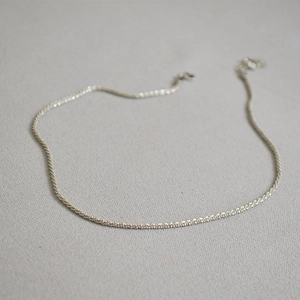 Macro detail of glossy silver choker chain showing the fine weave and adjustable clasp
