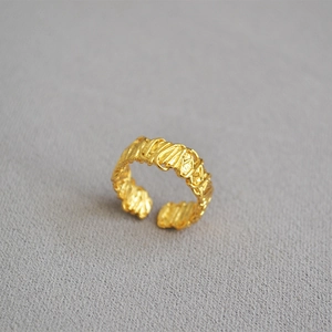 Detailed view of golden open ring with unique lava texture and molten metal design