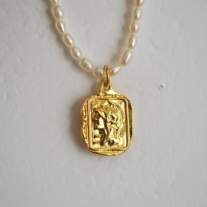 Close-up of vintage Roman coin pendant with freshwater pearls in French elegant style