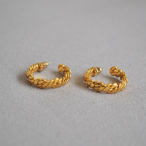 Vintage gold plated brass C-shape hoop earrings with a woven twist design on grey background