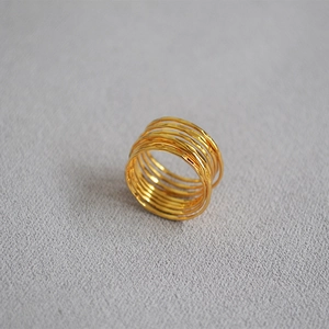 Detail of gold multi-layer wrap ring featuring artisanal hammered texture and wire finish