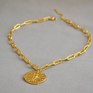 Dettaglio collana a catena a graffetta dorata con ciondolo a moneta ritratto romano