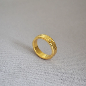 Detail view of gold-plated North Star ring with textured water ripple and inset zircon