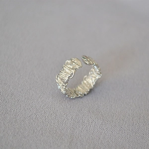 Macro detail of adjustable silver ring featuring a unique handcrafted wire-wrapped texture