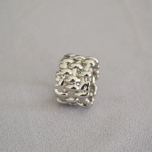 Detailed macro view of silver wide woven texture design on brass mesh band ring
