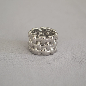 Macro shot of silver metal woven wide band ring with three-layer overlapping texture