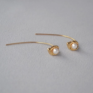 Minimalist gold thread drop earrings with white pearl buds on a soft grey surface