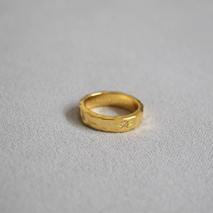 Macro detail of gold plated North Star ring featuring hammered texture and zircon stone