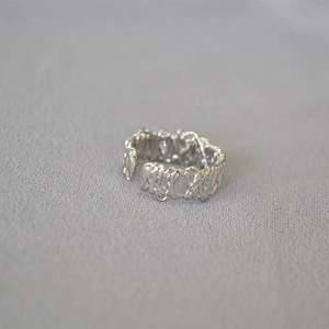 Macro view of minimalist silver ring with unique irregular filigree wire texture
