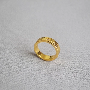 Detailed macro view of gold plated brass ring with textured surface and North Star zircon