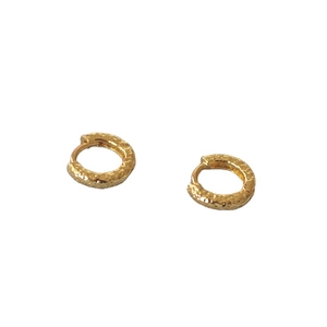 Minimalist golden hoop earrings with unique hammered texture on a white background