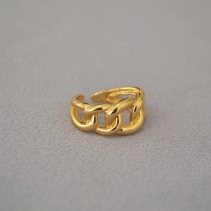 Macro shot of gold plated curb chain link ring showing polished texture and open design