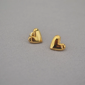 Macro shot of 14K gold plated heart stud earrings with a polished mirror finish detail