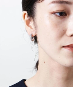 Close-up of minimalist silver hoop earring with pavé zircon stones on a model ear