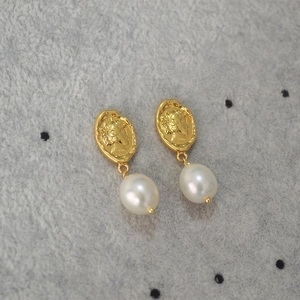 Detail shot of vintage gold medallion earrings featuring Queen relief and drop pearls