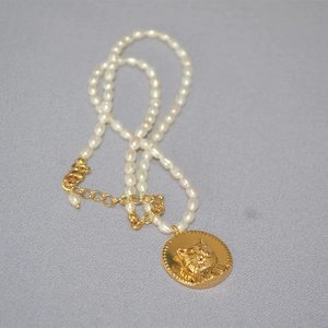 Freshwater pearl necklace with a golden cat head coin pendant and adjustable clasp