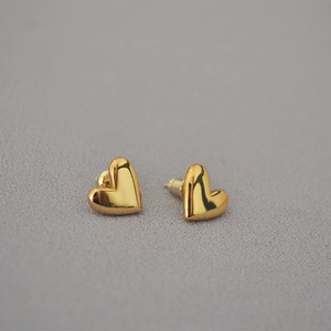 Minimalist heart-shaped stud earrings in polished gold finish for a sleek look