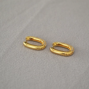 Polished 18K gold U-shaped huggie earrings with shimmering pavé zircon stones