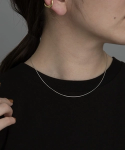 Collana a catena serpente d'argento ultra sottile sul collo della modella, stile minimale