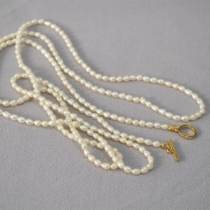 Gros plan d'un collier de perles de riz d'eau douce avec un fermoir à bascule OT doré chic