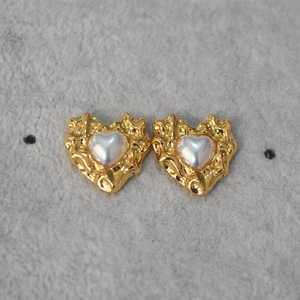 Vintage gold hammered heart earrings with inlaid white shell pearls on grey background