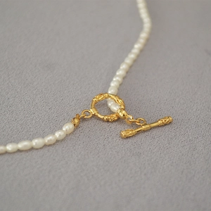 Collier de perles de riz vintage français avec fermoir OT doré sur fond en tissu gris