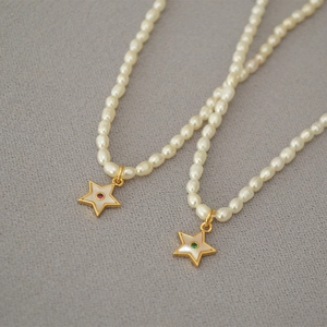 Elegant rice pearl necklace featuring a gold star pendant with mother of pearl inlay