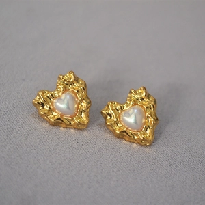 Detail of vintage heart earrings with hammered gold texture and inlaid shell luster