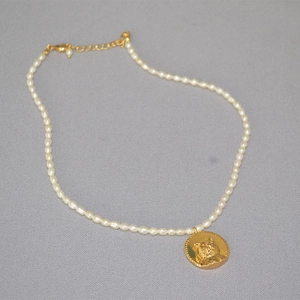 French style freshwater pearl necklace featuring a golden cat coin pendant and lobster clasp