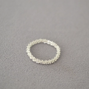 Macro view of minimalist silver chain link ring with a sparkling textured finish