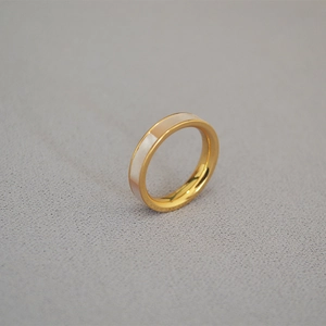 Vue détaillée d'une bague minimaliste dorée avec incrustation en nacre blanche colorée