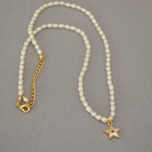 Detail of freshwater pearl necklace with star shell pendant and gold lobster clasp