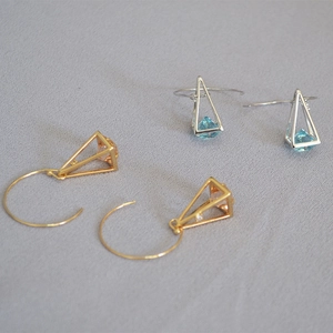 Geometric birdcage earrings with dangling faceted zircons in gold and silver finish