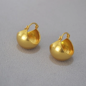 Detailed view of matte gold hollow dome earrings with secure snap-on closure