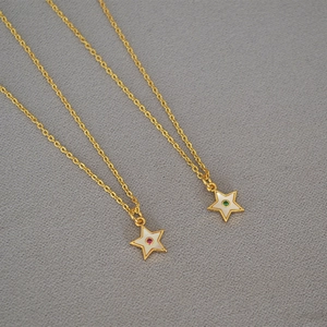 Detail of star pendants with mother of pearl and gems on delicate gold chains