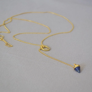 Detail of lapis lazuli conical pendant on a matte gold Y-shaped chain necklace