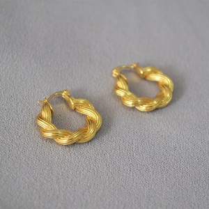 Elegant gold twisted hoop earrings with woven texture from a professional 45-degree angle