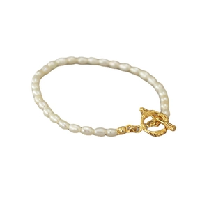 Collier de perles de riz élégant avec fermoir à bascule fleuri doré sur fond blanc pur
