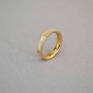 Détail de bague en laiton doré avec incrustation élégante de nacre blanche irisée